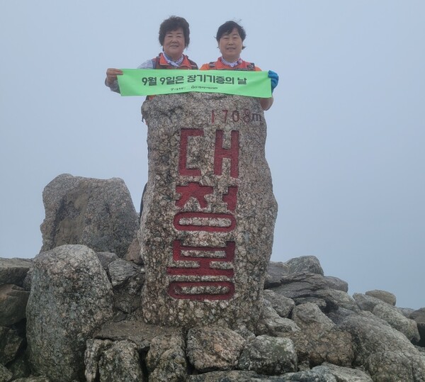  ▲지난 8월 15일설악산 대청봉에서 새생명나눔회 총무와 장기기증의 날 홍보촬영을 하고 있는 엄해숙 씨(왼쪽). ⓒ데일리굿뉴스