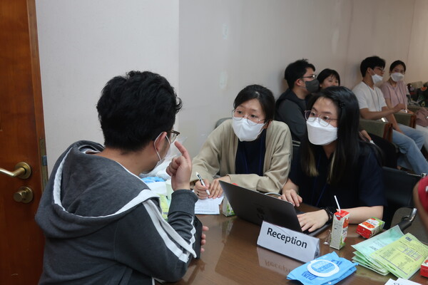 ▲접수대에서 눈이 잘 안보인다고 말하고있는 유학생과 경청하는 외대교회 청년들. ⓒ데일리굿뉴스