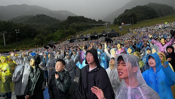 ▲CCC 여름 대학생수련회에서 학생들이 비를 맞으며 뜨겁게 찬양하고 있는 모습. ⓒ데일리굿뉴스