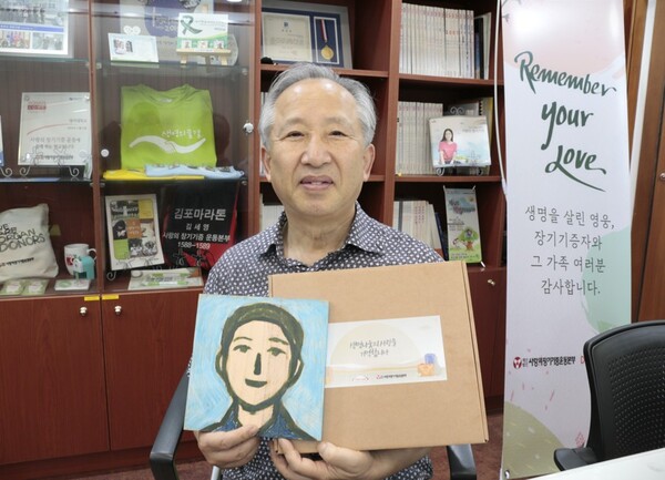  ▲추석 선물을 전달받은 도너패밀리 강호 회장이 아들 故 석민 군의 사진과 함께 남긴 기념사진.ⓒ데일리굿뉴스