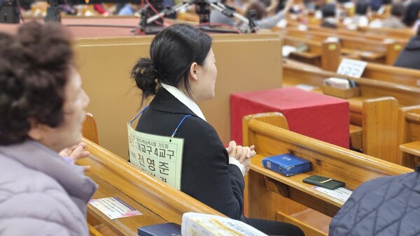 ▲한 학부모가 두 손을 모아 기도하고 있다.ⓒ데일리굿뉴스